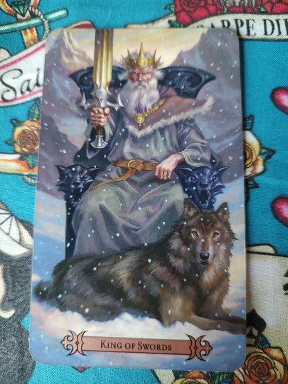 Card from the Modern Spellcaster's Tarot deck. 
King of Swords.
A king, a white man with white hair and beard, seated on a throne in the snow. A wolf at his feet. He is holding up a sword on his right hand. He does look pretty pissed.
