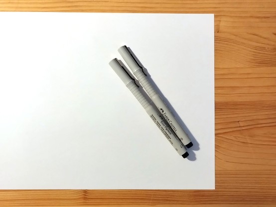 You can see a photo of a blank, white sheet of paper with 2 pens on it