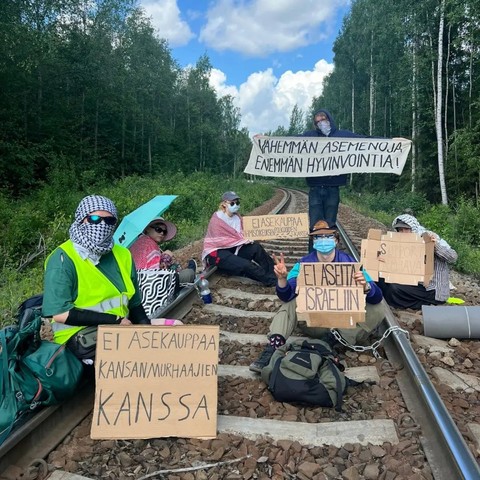 Image from @ppalasiksi social media.

Blockers on the railway track to the SSAB factory in Hämeenlinna. Two are visibly chained to the tracks.

Signs include "Ei asekauppaa kansanmurhaajien kanssa", "Ei aseita Israeliin", "Support Rojava", "Ei asekauppaa ihmisoikeuksen polkujoiden kanssa", "Vähemmän asemenoja enemmän hyvinvointia".

Demands included:

- The arms trade with countries that violate human rights must be stopped and existing agreements must be terminated. Finland must actively pursu…