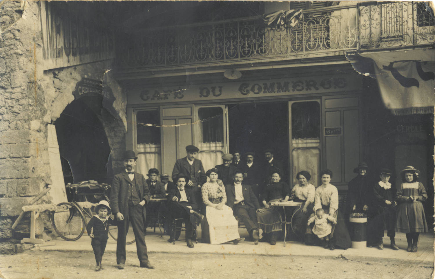 Une dizaine de personnes posant devant le café du commerce à Laparade vers 1920.