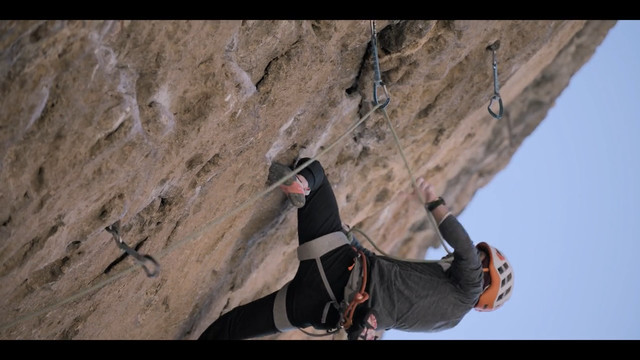 Climber putting the rope between his teeth.