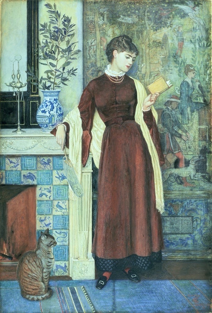 At Home, 1872, by Walter Crane: A young woman in a long, maroon dress stands elegantly, holding a book and gazing thoughtfully. She is next to a decorative fireplace and a patterned blue tiled wall, while a gray tabby cat sits nearby. The background features a vibrant artwork