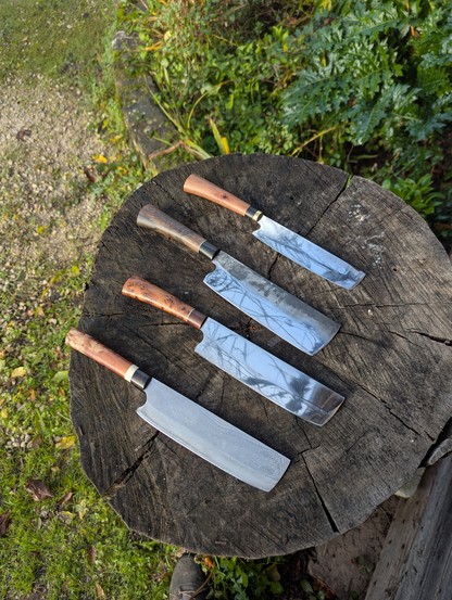 4 couteaux de cuisine Nakiri posés sur un billot, vu de haut .