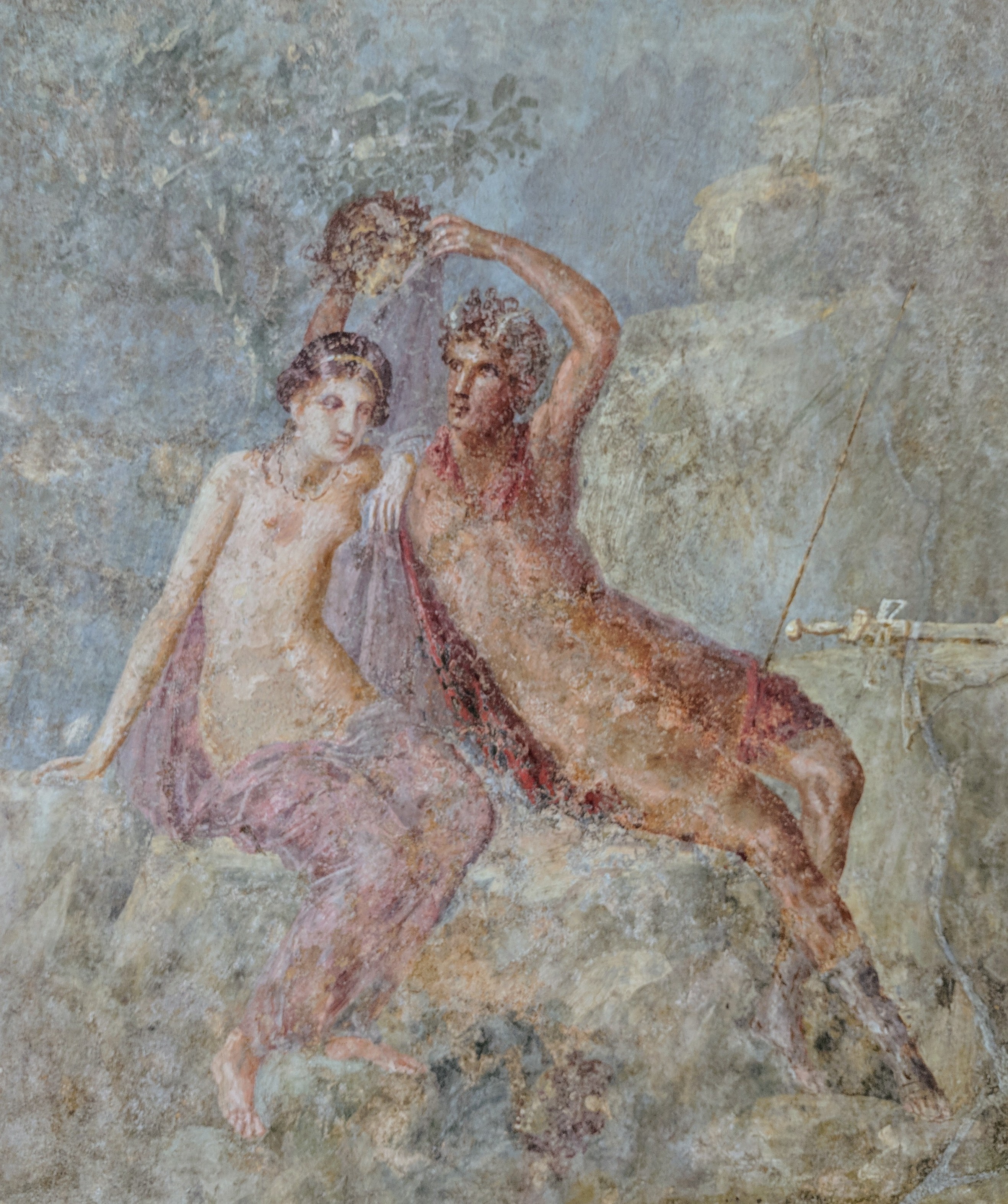 Peinture de Pompei. Andromède est sur la gauche assise. Ellee st torse nue. Sur sa droite, assis à coté d'elle, Persée, guère plus habillé. Il tient au dessus de la tête d'Andromède, la tête de Méduse. Andromède regarde vers le bas. Probablement qu'elle regarde le reflet de la tête dans l'eau