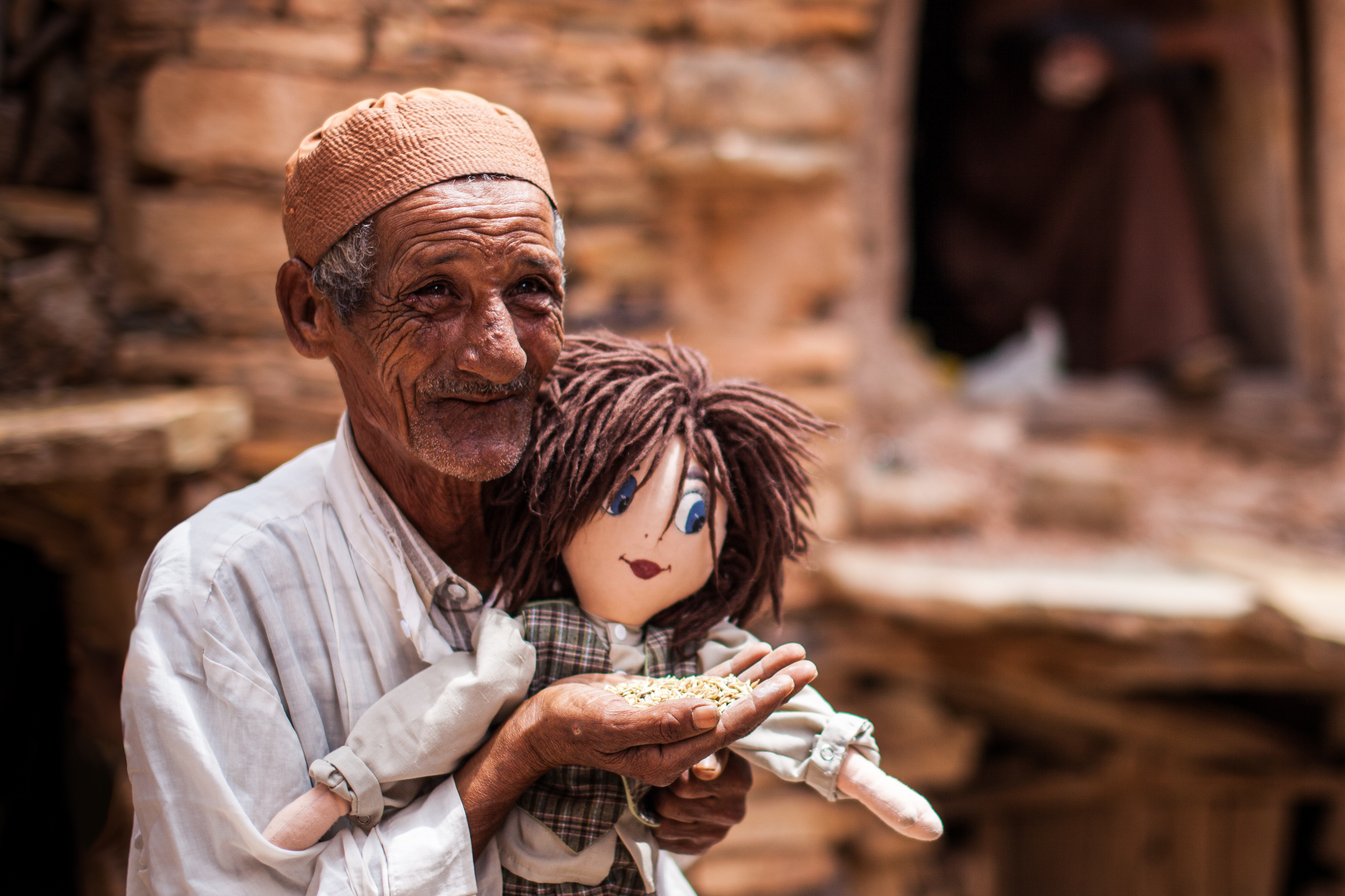 Photo of an old Moroccan man Lamine of an Igoudar (i.e. guardian of a community granary), with a rag doll. Photo of an old Moroccan man Lamine of an Igoudar (i.e. guardian of a community granary), with a rag doll.