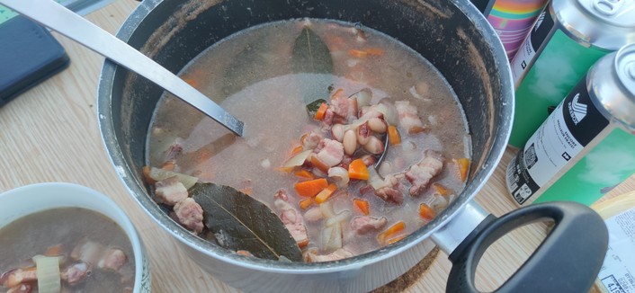 Cocotte contenant la soupe, haricots secs , carottes, lard fumé, feuilles de laurier, oignons