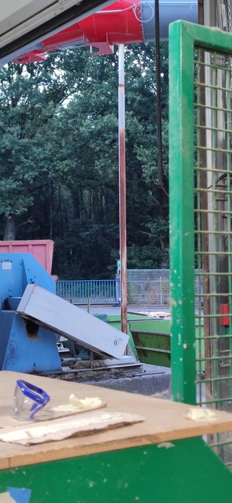 Depuis mon poste de travail, à travers la porte de l'atelier grande ouverte pour laisser entrer la fraîcheur de l'aube, au-delà de l'enceinte de l'usine, une forêt sombre et mystérieuse me tend les bras.