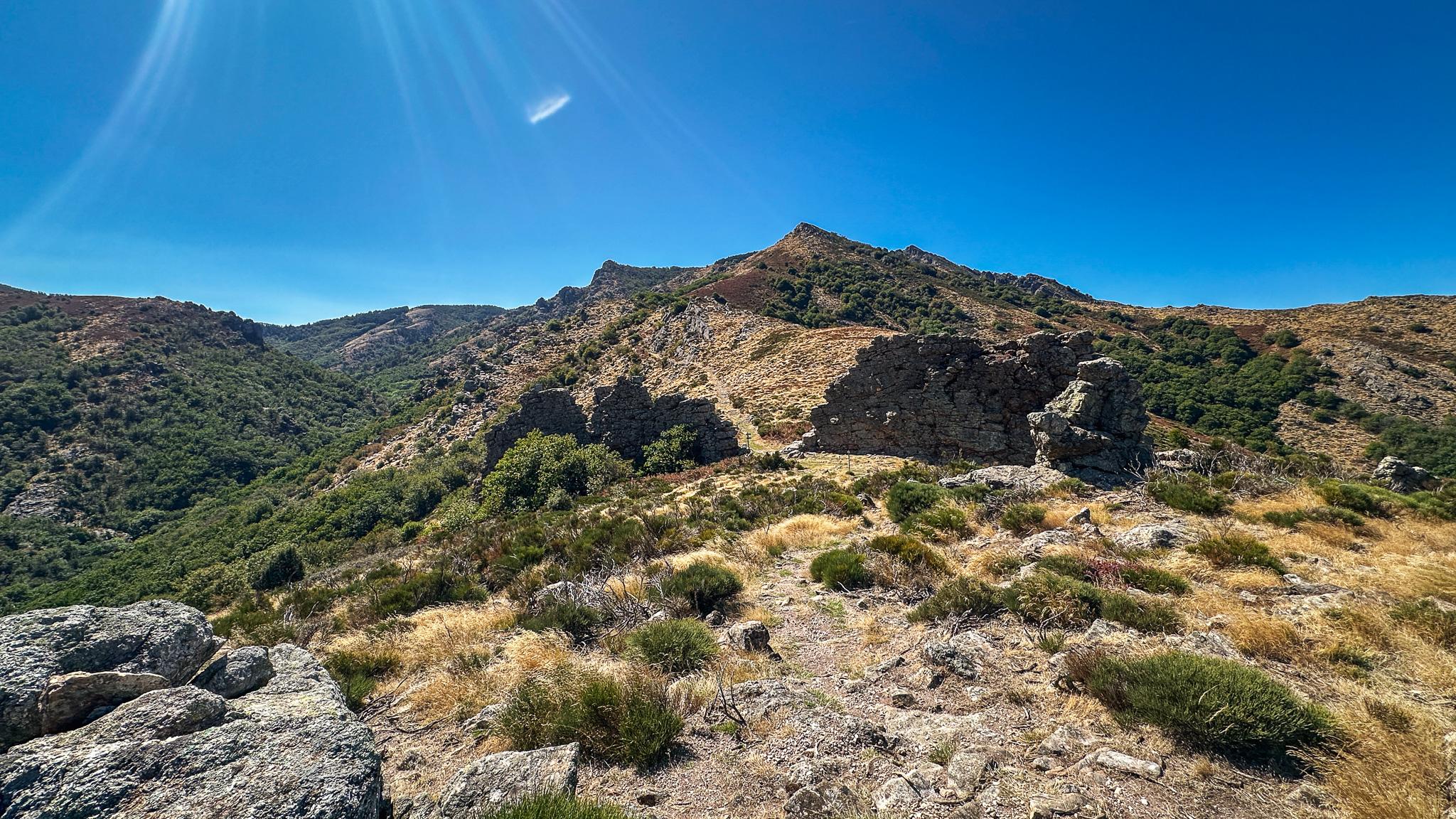 Un sentier de randonnée franchit le portail de Roquandouire, une formation rocheuse naturelle qui laisse penser à un passage dans un mur de construction humaine, dans le parc naturel du Haut Languedoc