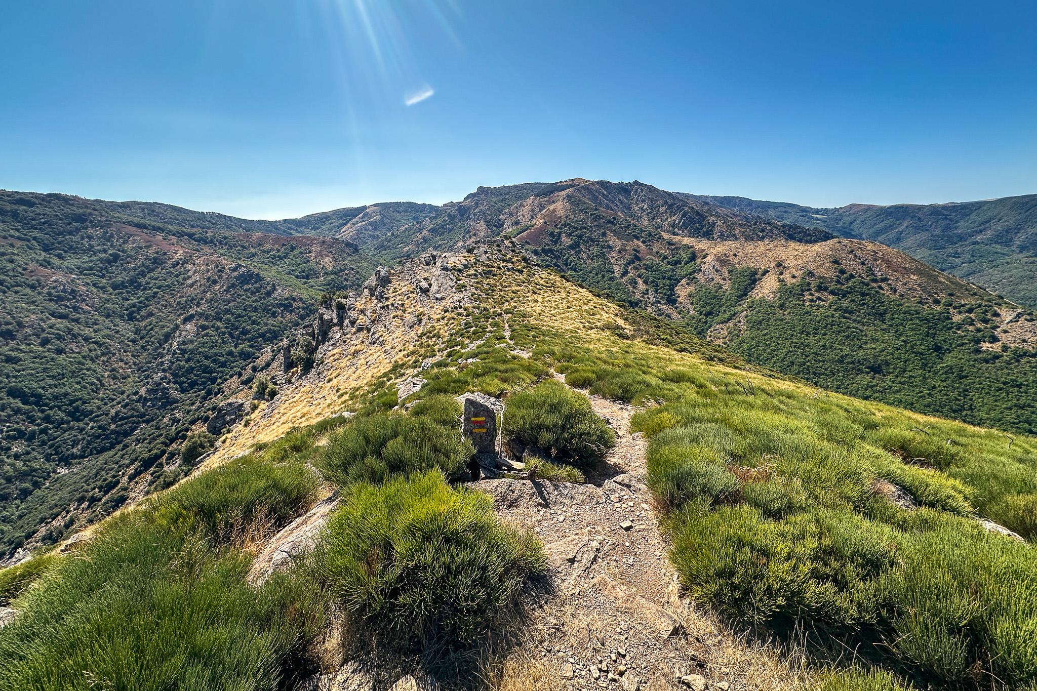 un sentier de randonnée balisé suit la ligne d’une crête laissant voir un super panorama de moyenne montagne parsemée de garrigue