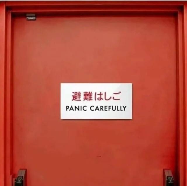 Une porte rouge avec un panneau en chinois ou japonais et le texte : panic carefully.