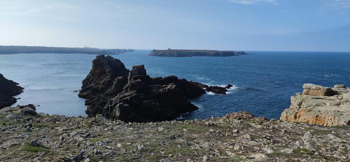 L'océan depuis la pointe de Cadoran, un groupe de rochers s'avancent dans la mer. Plus loin, l'île Keller et la pointe nord de Ouessant séparées par un chenal.