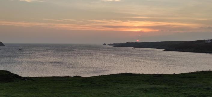 Coucher de soleil sur la baie de Lampaul le soleil disparaît à l'horizon dans une couche de nuages