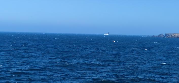 Le Fromveur II arrive au large du port du Stiff. Le ciel est bleu, il y a de la houle.