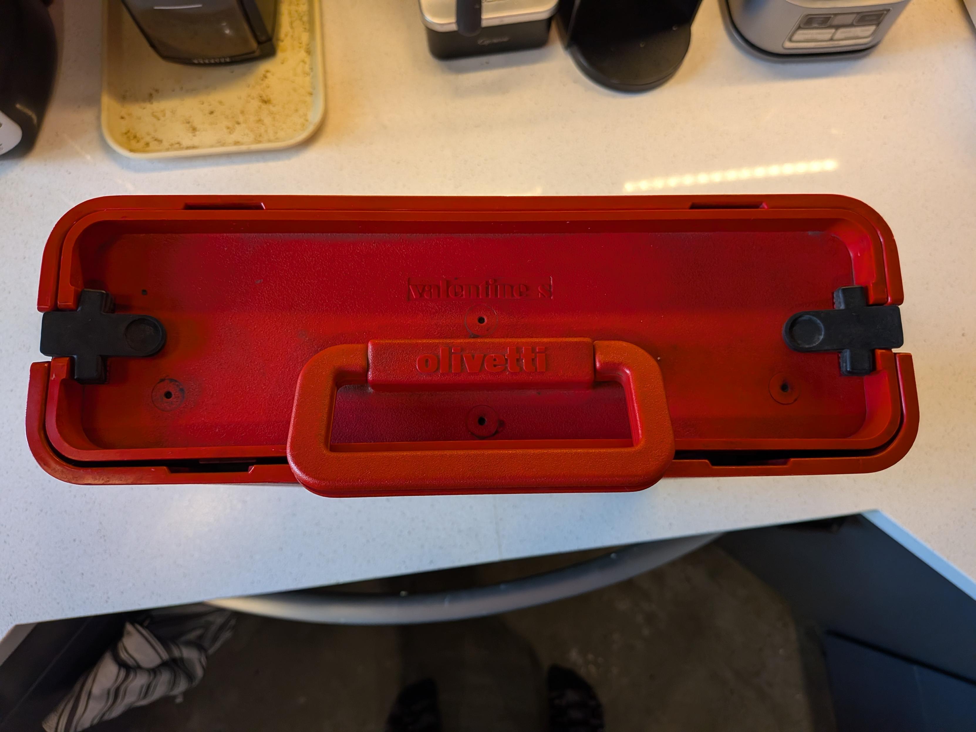 A red, injection-molded ABS plastic Olivetti Valentine portable manual typewriter from 1969.