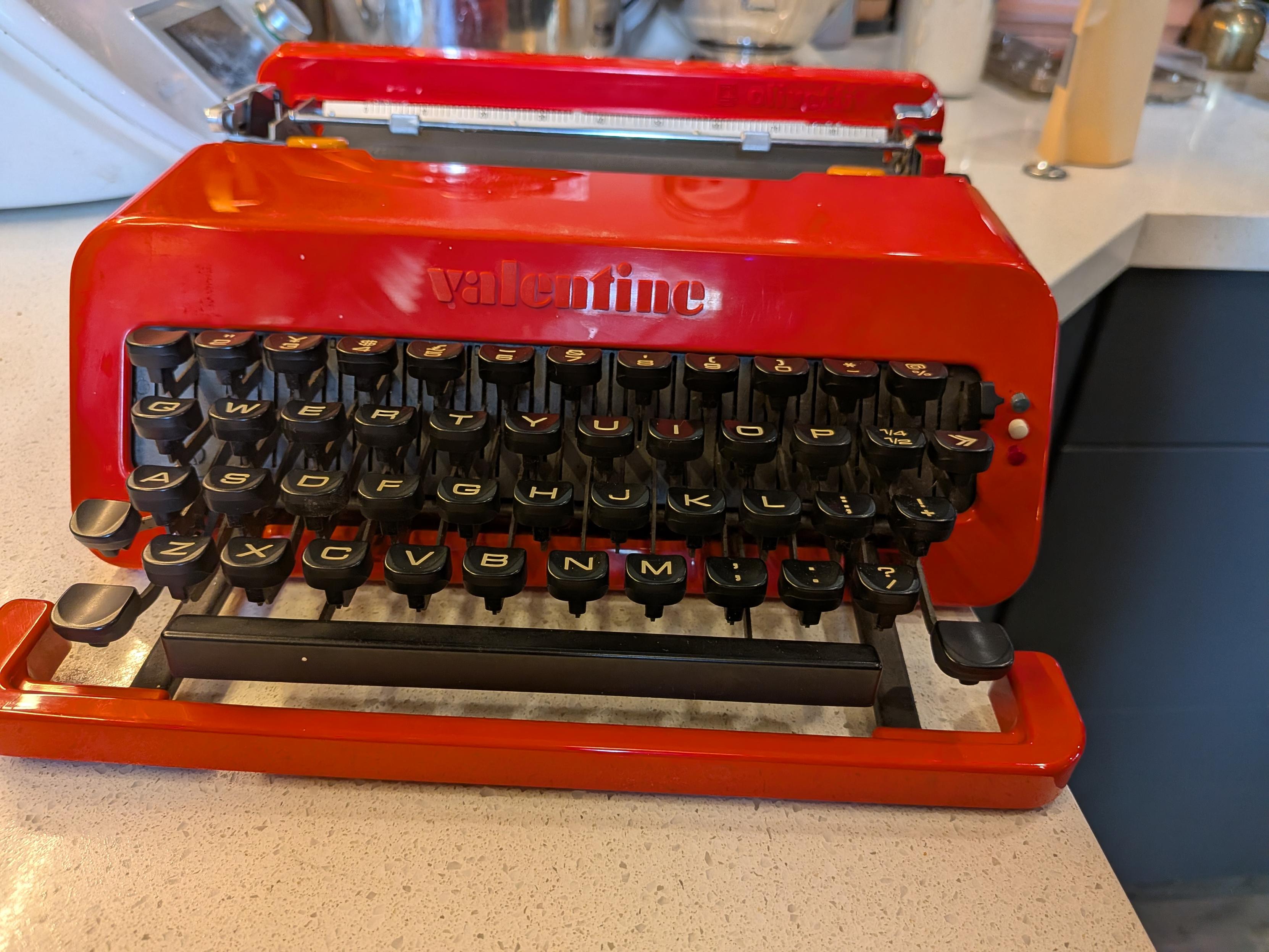 A red, injection-molded ABS plastic Olivetti Valentine portable manual typewriter from 1969.