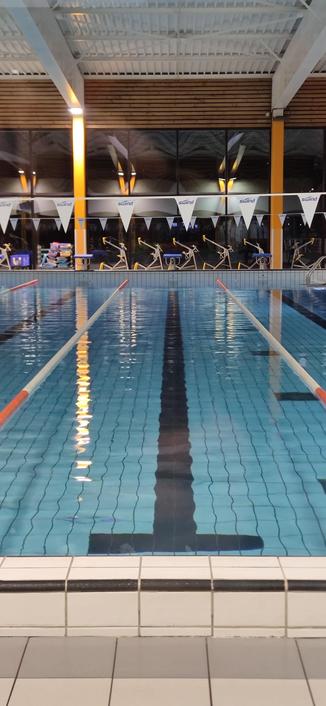 ligne d'eau de la piscine de Pontivy après fermeture des bassins. Les éclairages du bassin se reflètent à la surface.