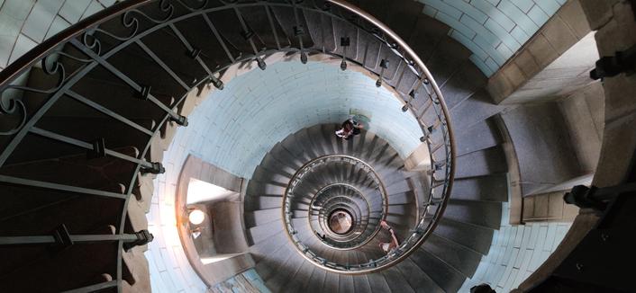 escalier en colimaçons du phare d'Eckmühl vu depuis le sommet. 290 marches plus 13 marches de l'échelle finale (non visible). l'escalier court sur la paroi du phare, côté intérieur une rambarde protège du vide.