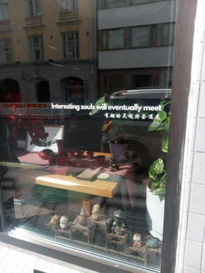 Window of a tea shop in central Helsinki, with a text reading "Interesting souls will eventually meet" / "有趣的灵魂终会遇见"