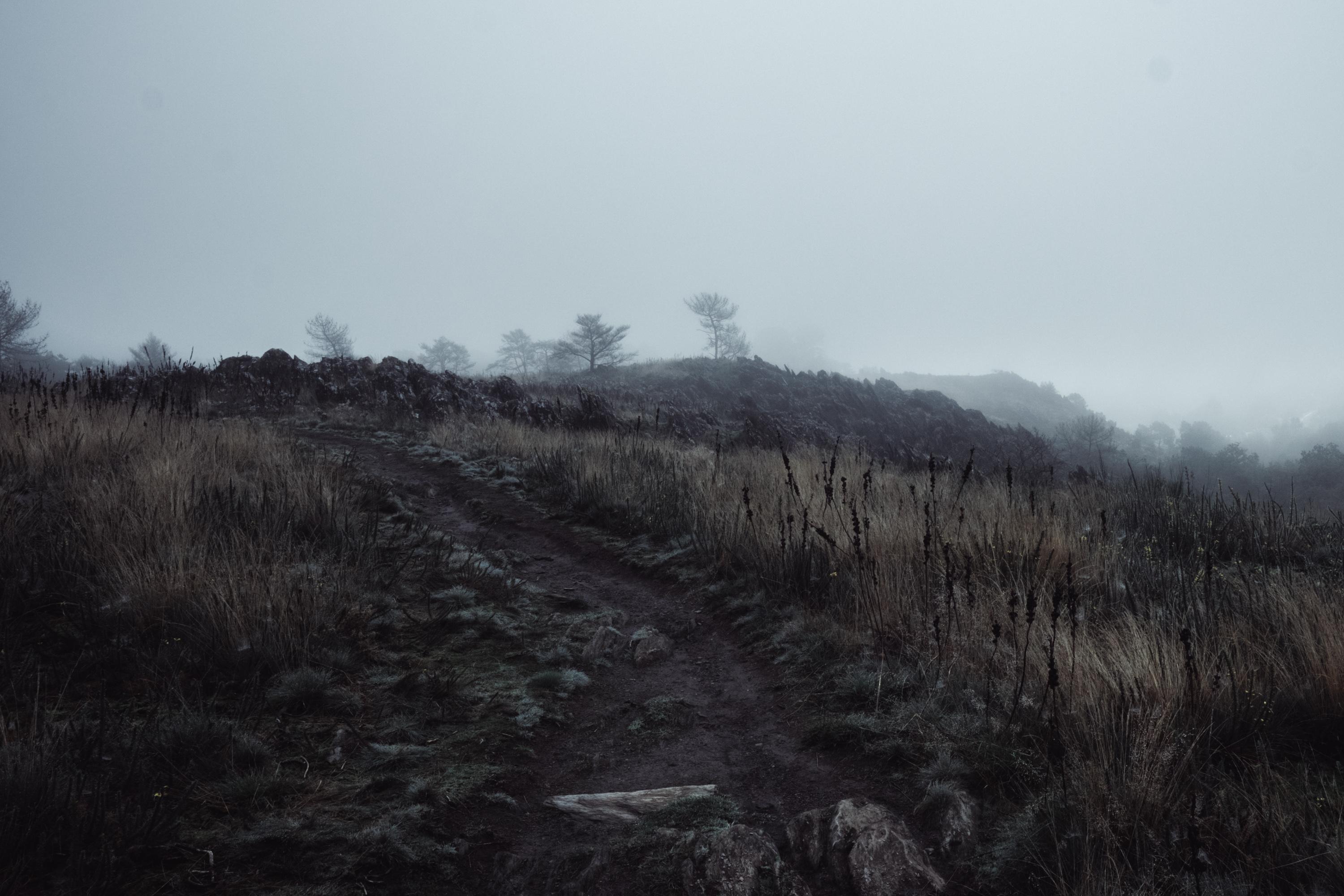 Dimmed hike on a hill on a foggy weather